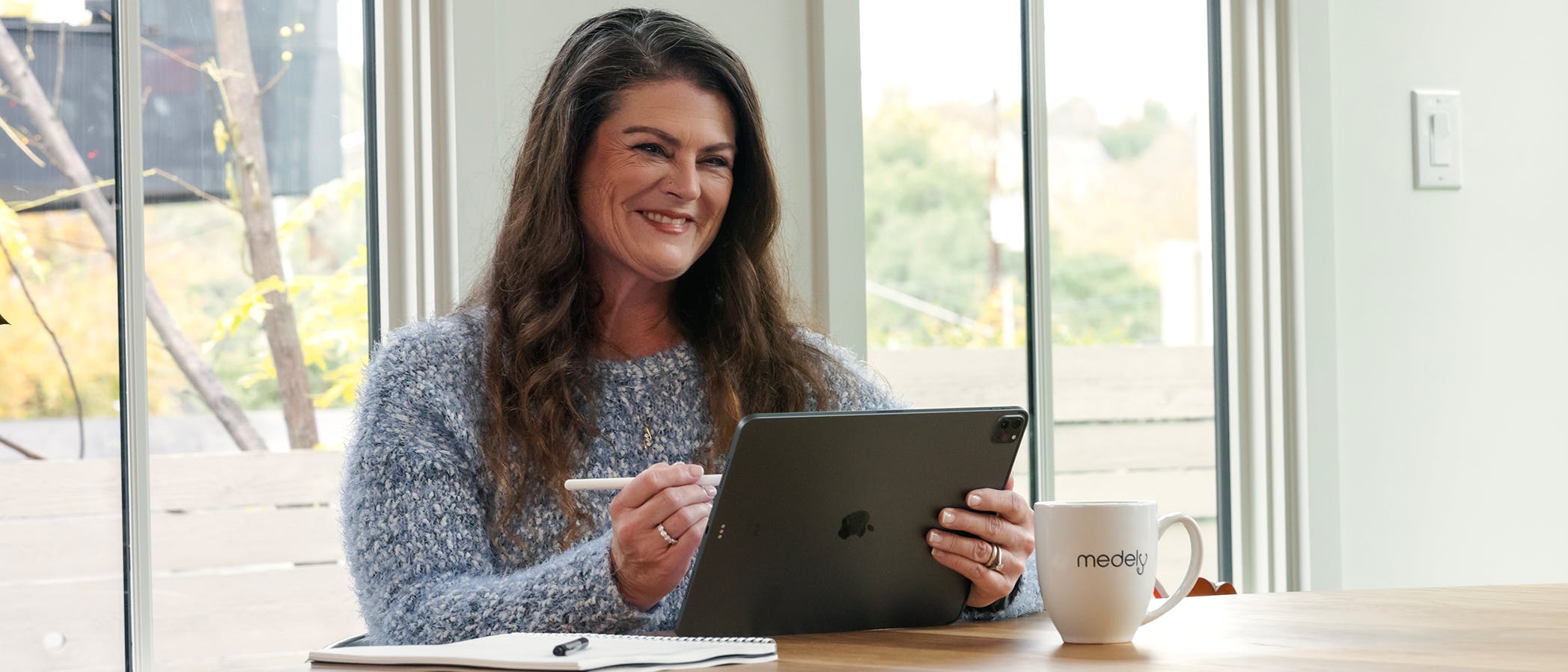 Image of RN administrator smiling while holding devices