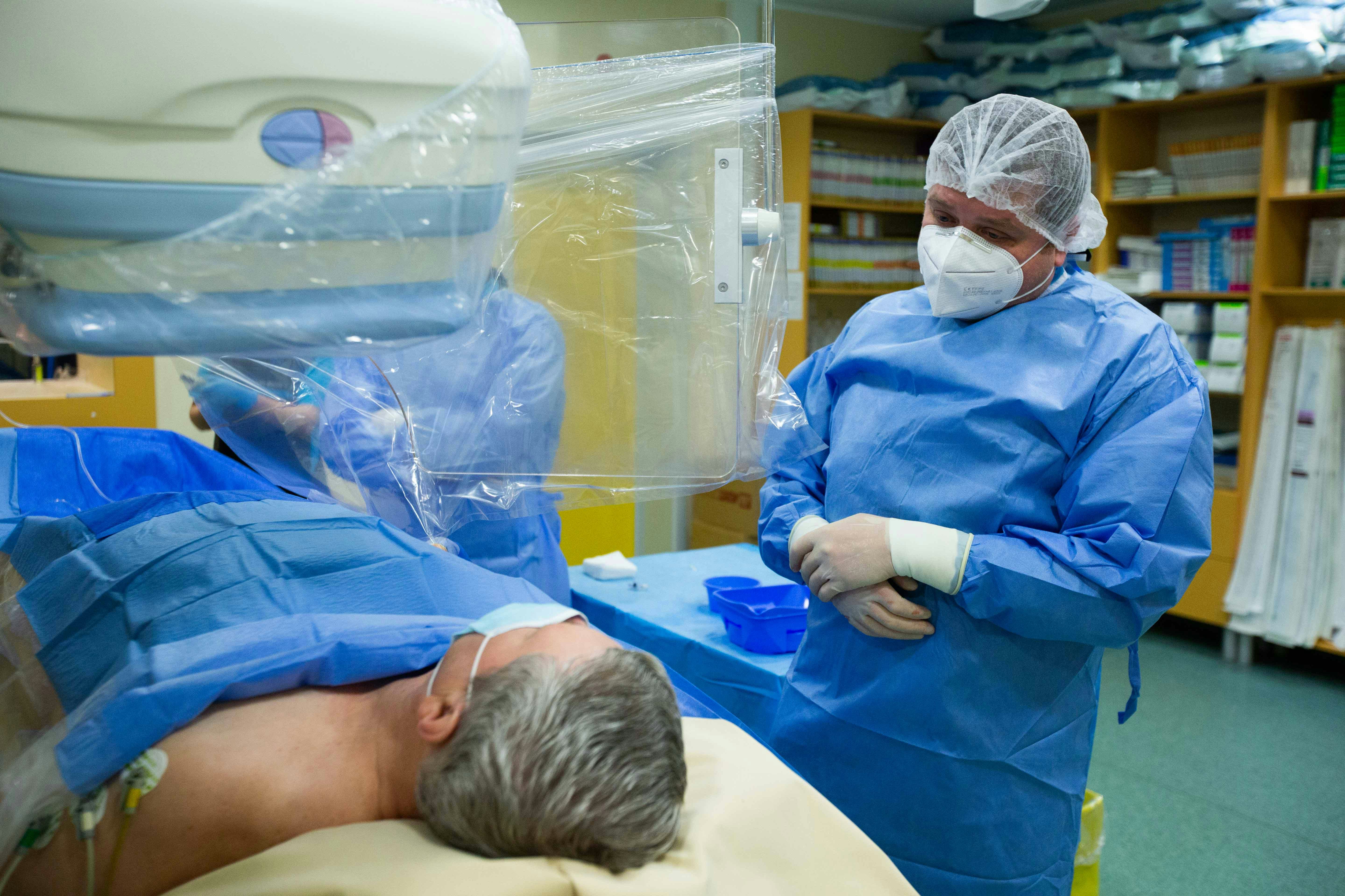 Doctorul Roberto Haret discută cu pacientul aflat pe masa de angiografie