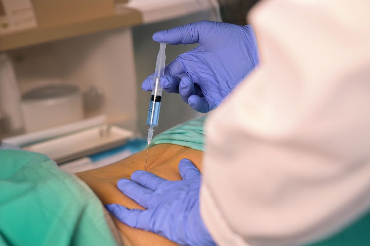 Medic efectuand o infiltratie in coloana.