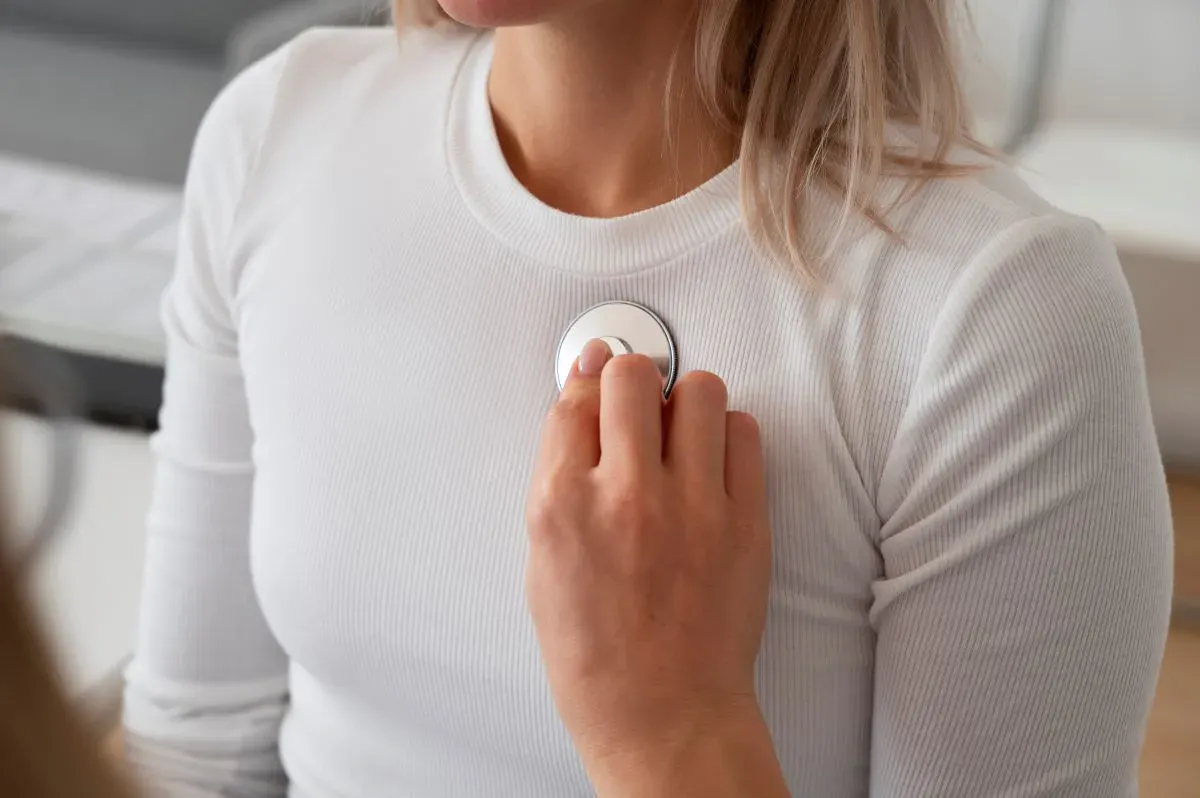 medic folosind un stetoscop pentru a examina o pacienta 