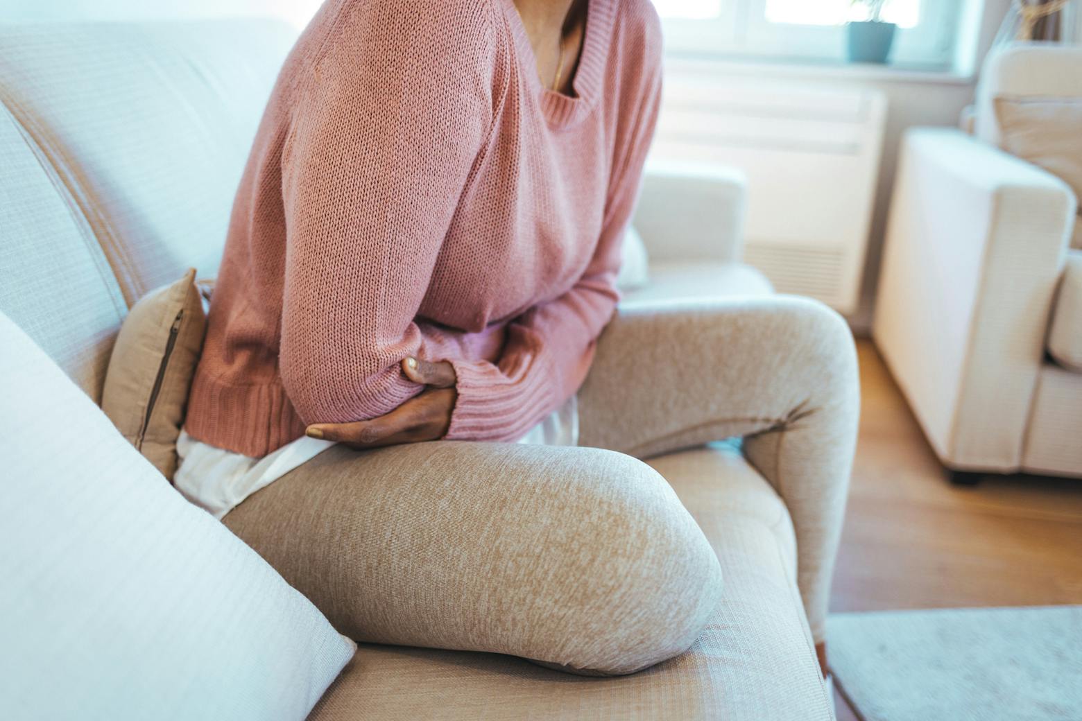 Woman holding her stomach area representing the transvaginal mesh case settled.
