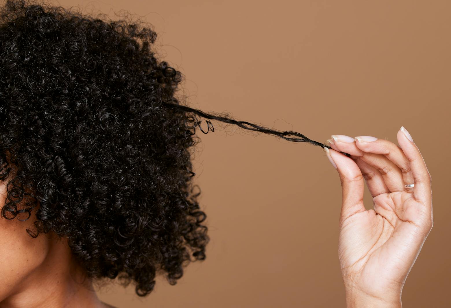 Black woman with curly hair representing hair straightener/relaxer litigation.