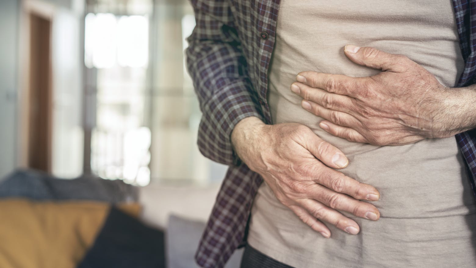Man holding his stomach and bladder representing a California judge approving expert witness in Zantac trial over bladder cancer claims.