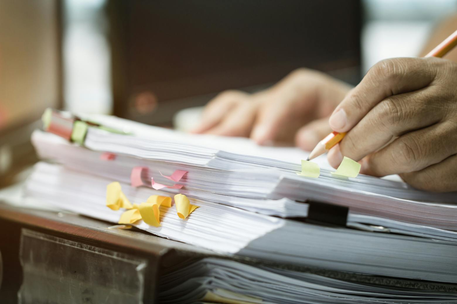 A lawyer with a stack of papers representing attorneys defending cases with awaiting replies.