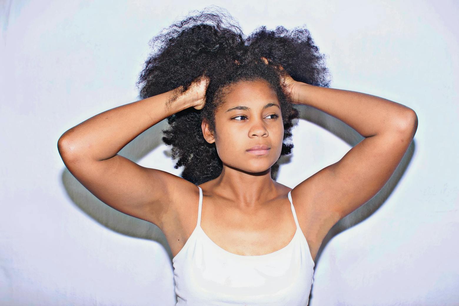 Image of an African-American woman holding her hair representing the hair relaxer lawsuits.