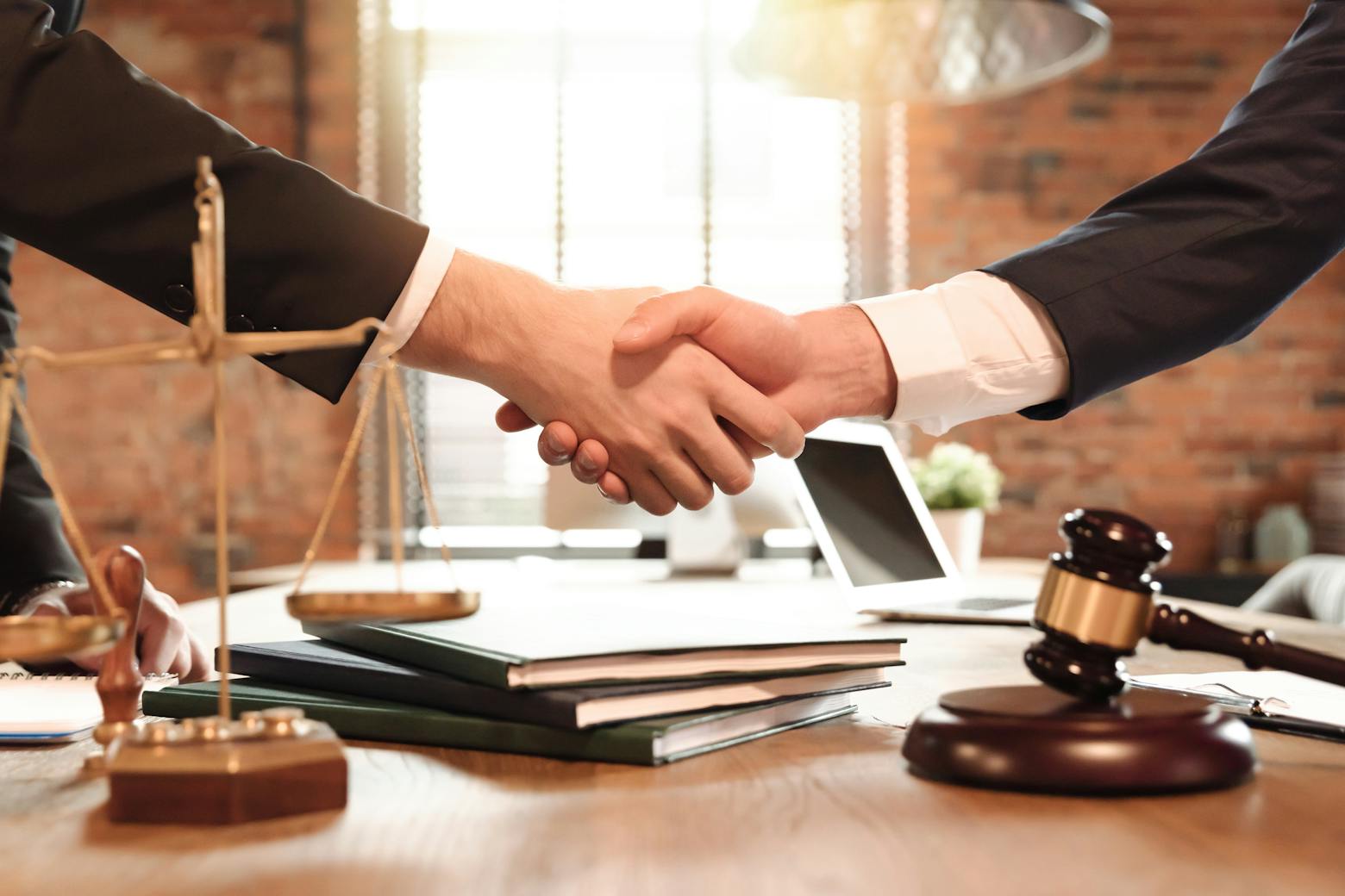 Lawyers shaking hands representing the Roundup litigation push for settlement.