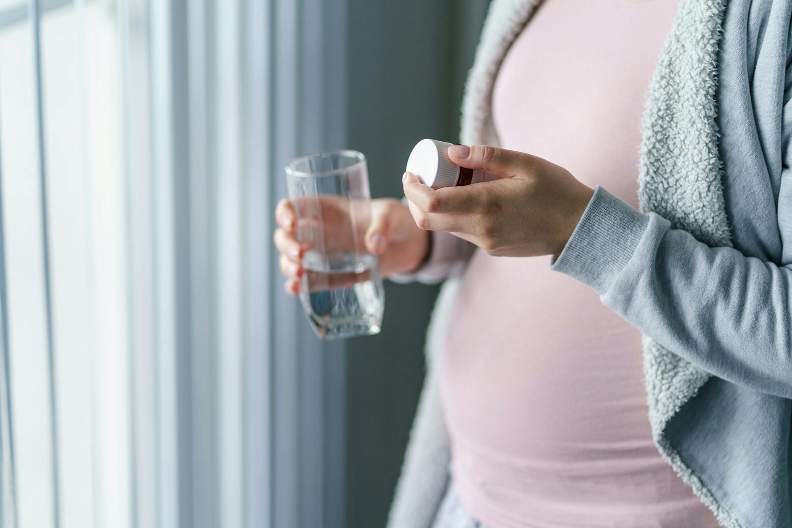 A pregnant woman taking a pill representing the Tylenol autism lawsuits.