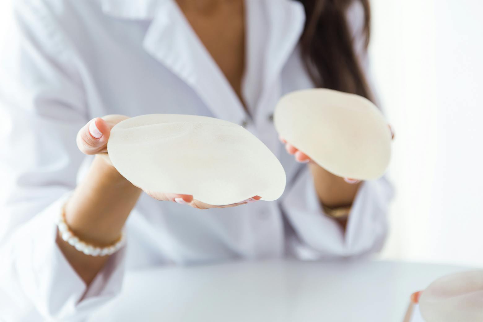 A woman holding textured breast implants representing additional breast implant cancers discovered.