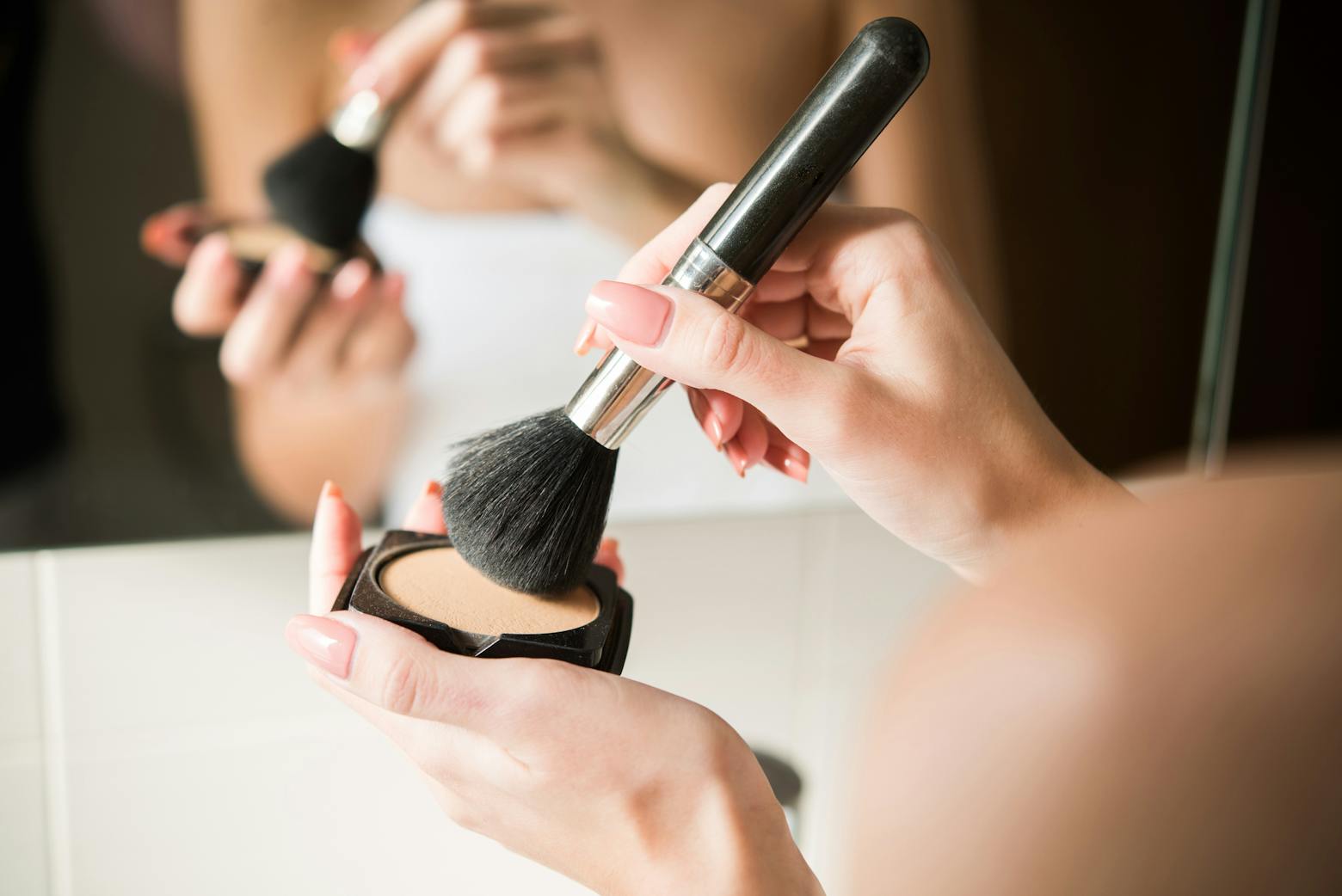 A woman using powdered cosmetics representing the talcum powder supplier filing for bankruptcy.