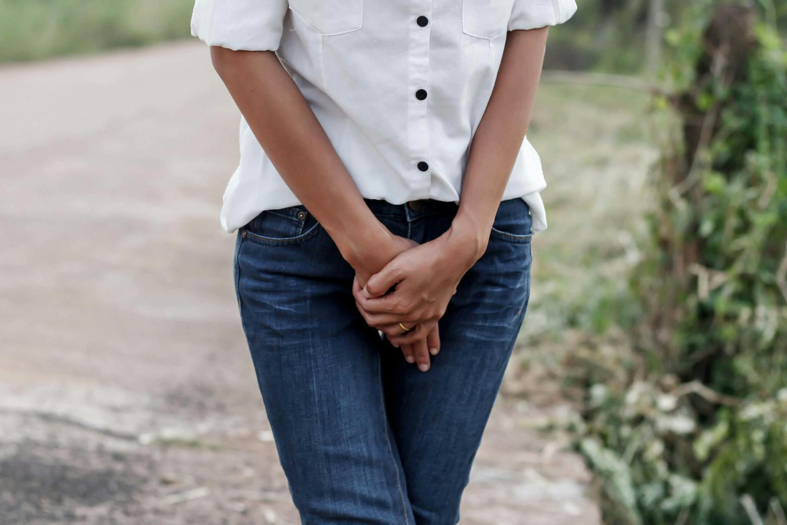 A stock photo of a woman holding her reproductive organs in relation to Dr. Amy Reed's work with power morcellators.