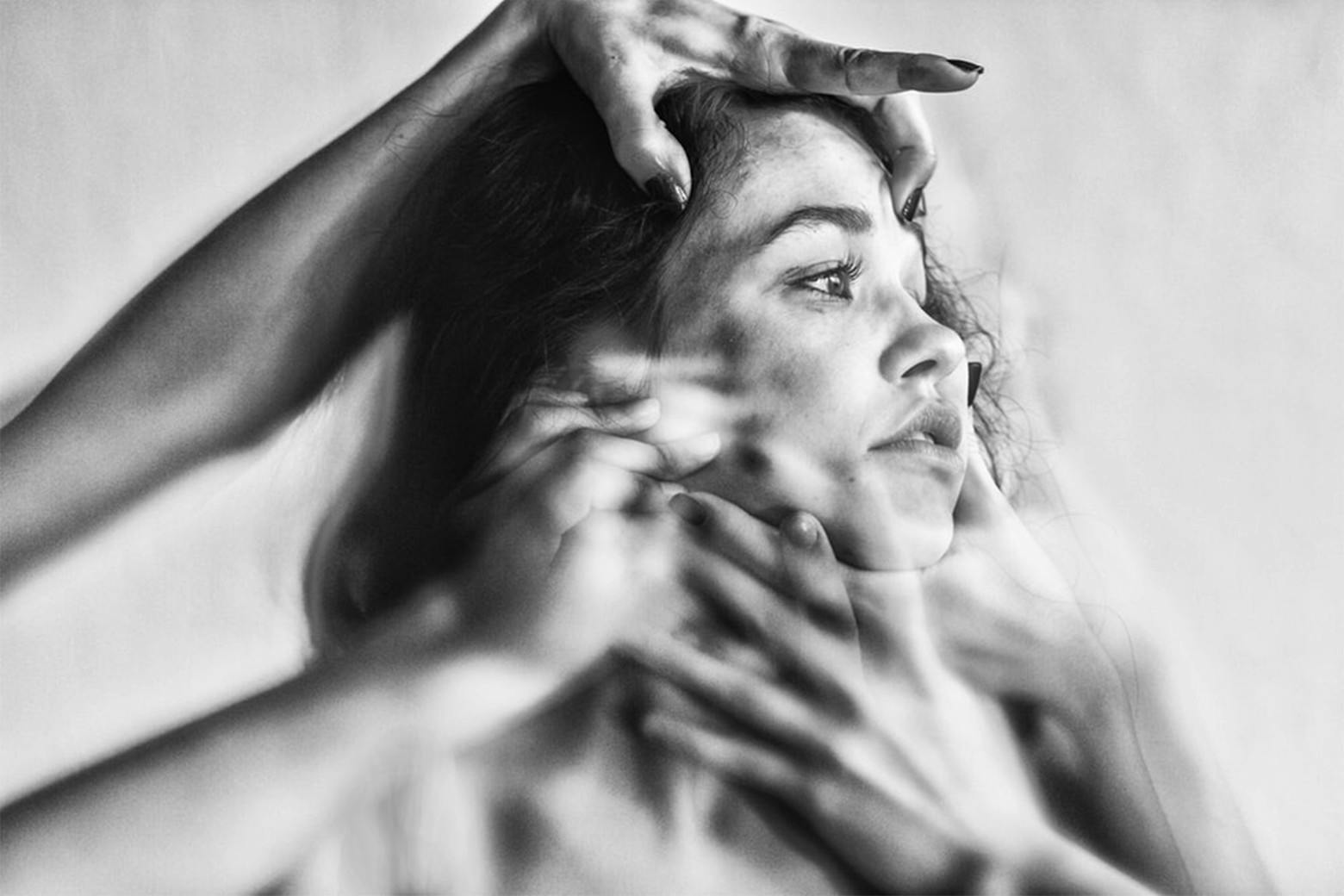 Girl's head held by many different hands to symbolize the many facets of delay to mental health care