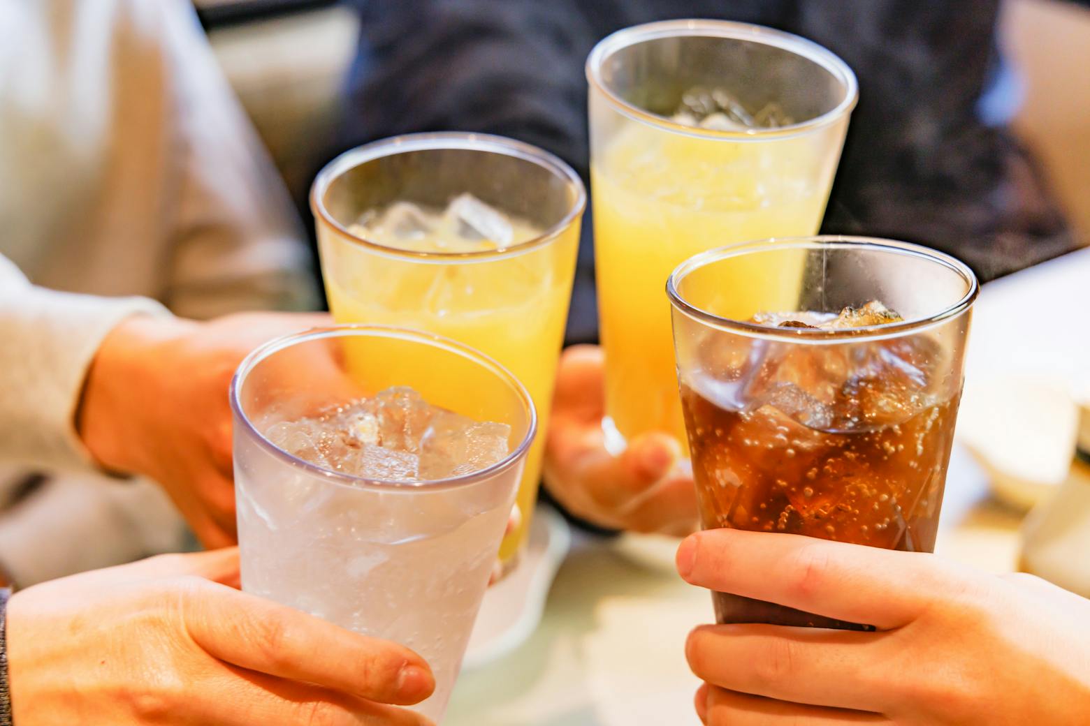 Group of people holding sodas representing aspartame to be declared possibly carcinogenic.