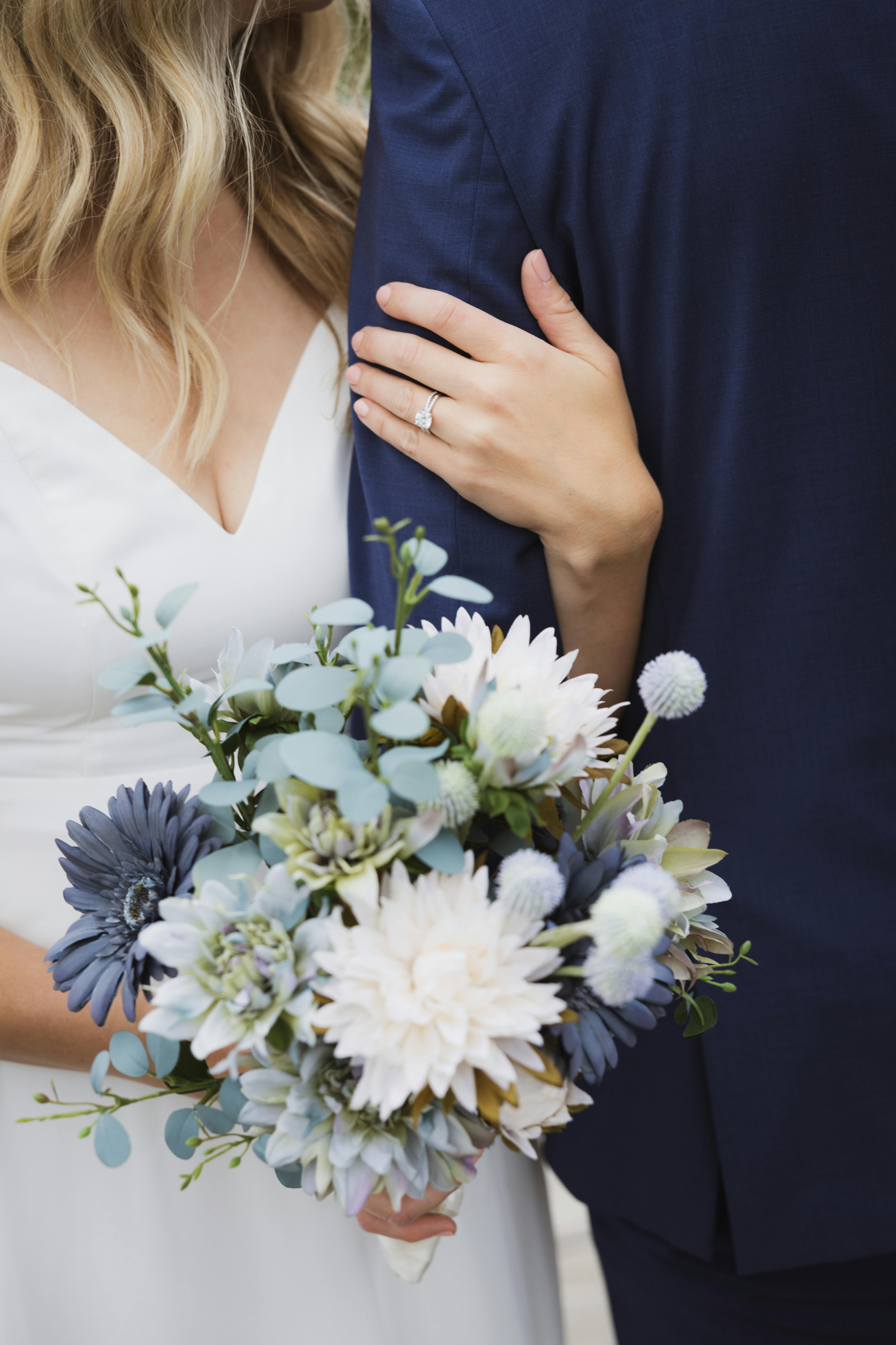 wife holding husband's arm while holding flowers in opposite hand