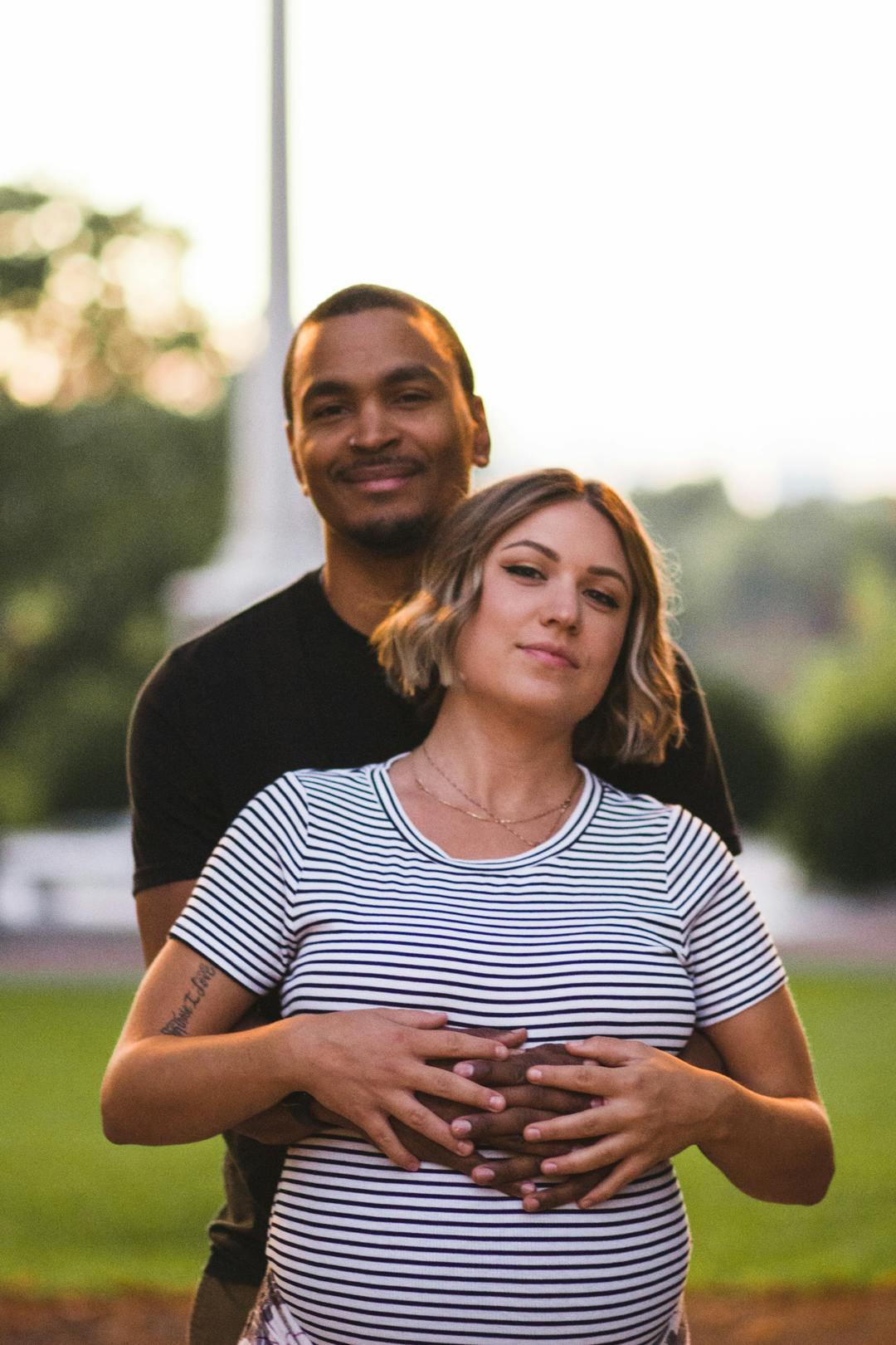 couple smiling and hugging each other staring directly at the camera