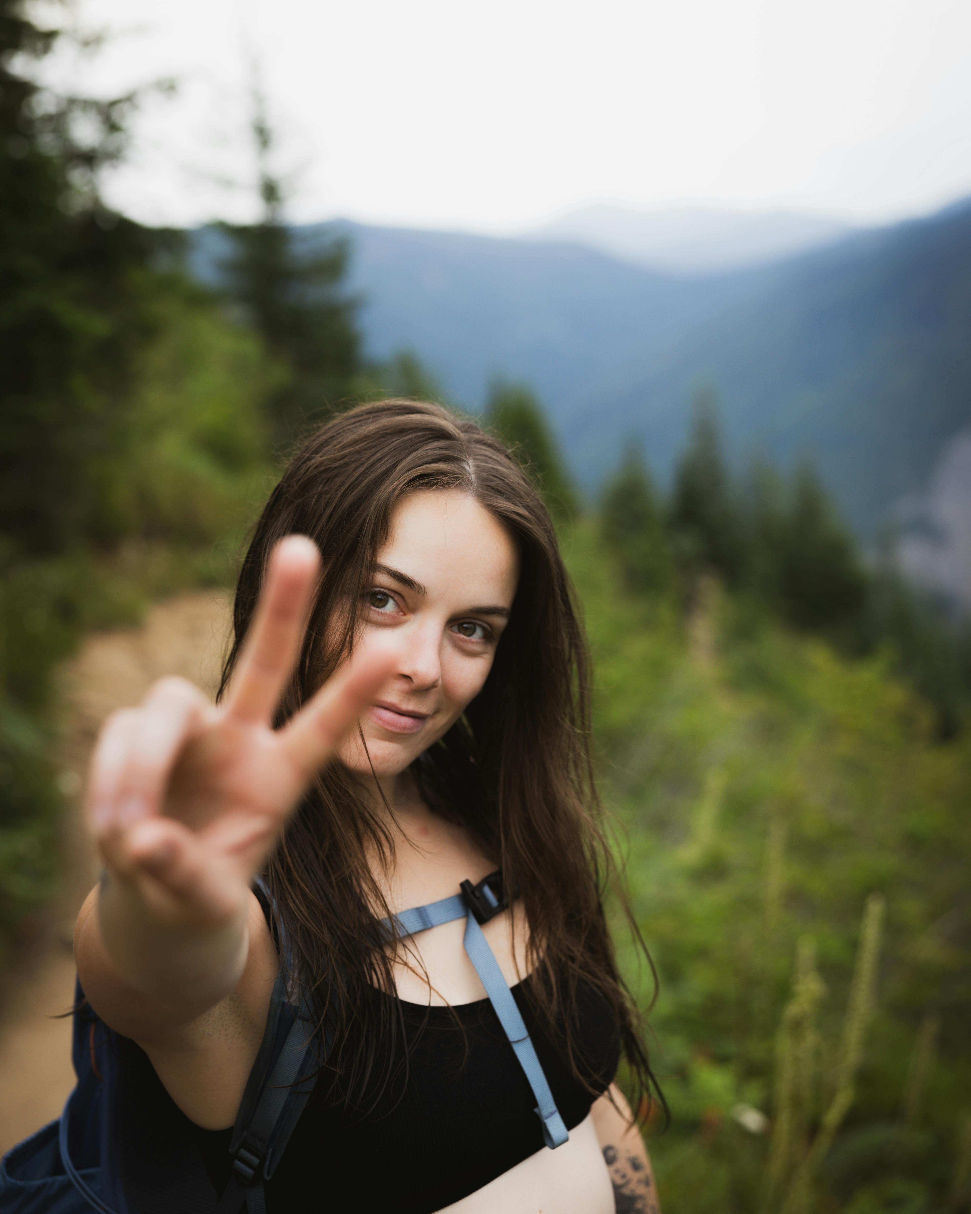 woman smiling holding up the peace sign