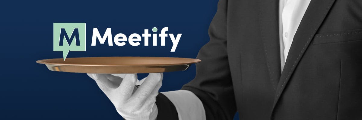 A waiter in a black jacket and white gloves serving up a tray with the Meetify logo on it
