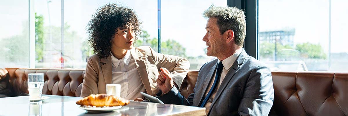 A recruiter handles an interview at a coffee shop.