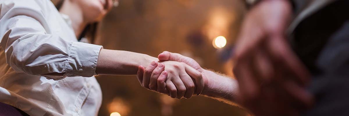 A woman shakes hands with a business associate during a face-to-face meetup.