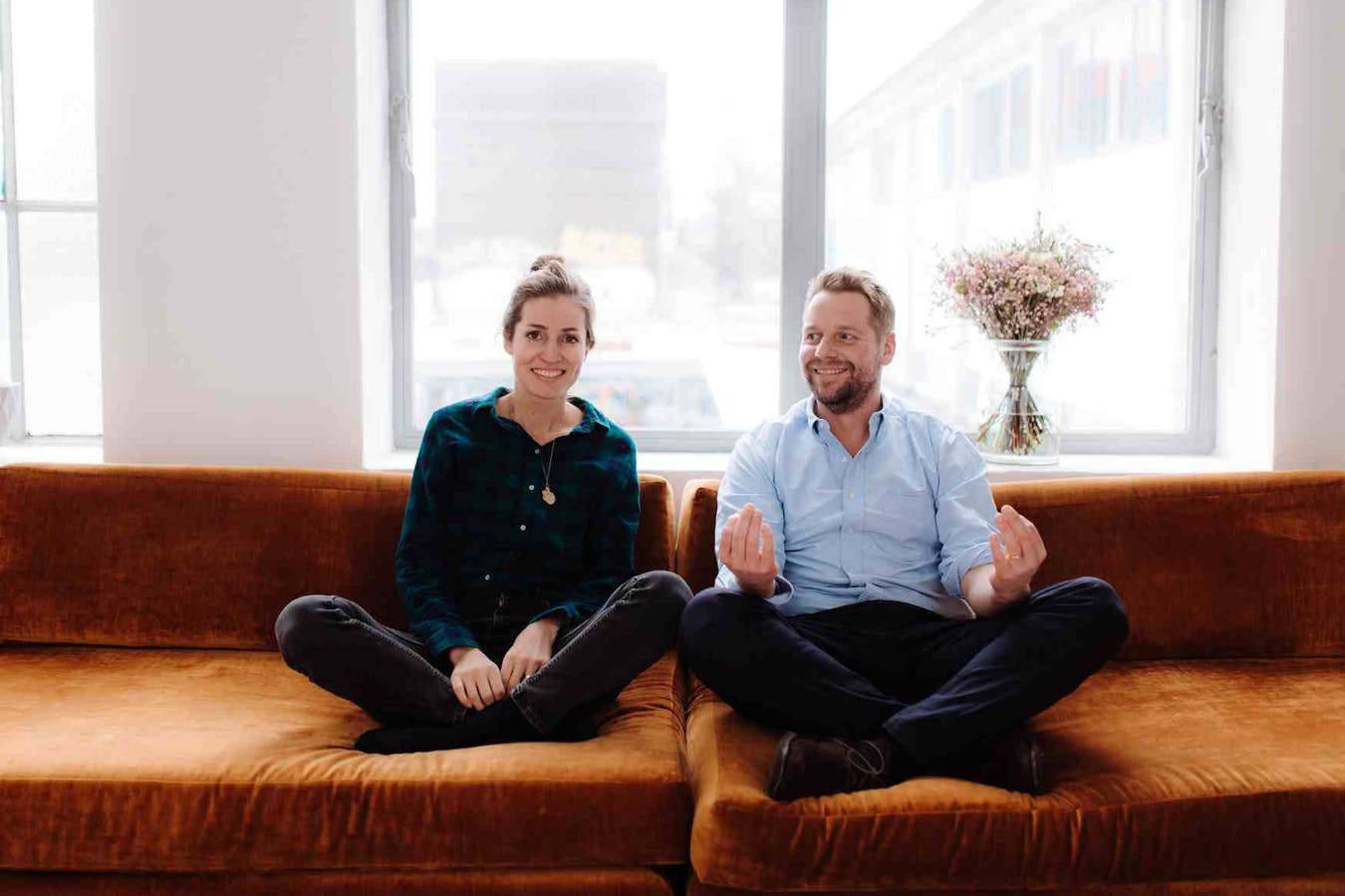 Zwei Personen sitzen nebeneinander auf dem Sofa.