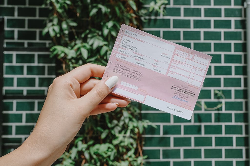 Frau hält Rezept in der Hand und steht vor eine grünen Wand.