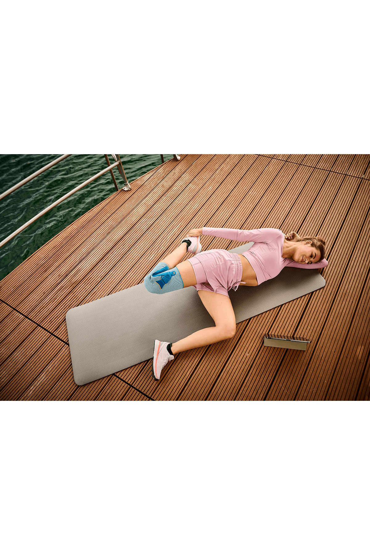 Frau macht Yoga mit Kniebandage