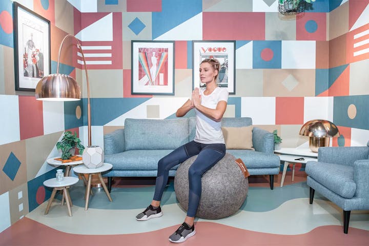 Frau sitz im Wohnzimmer auf dem Stryve Ball