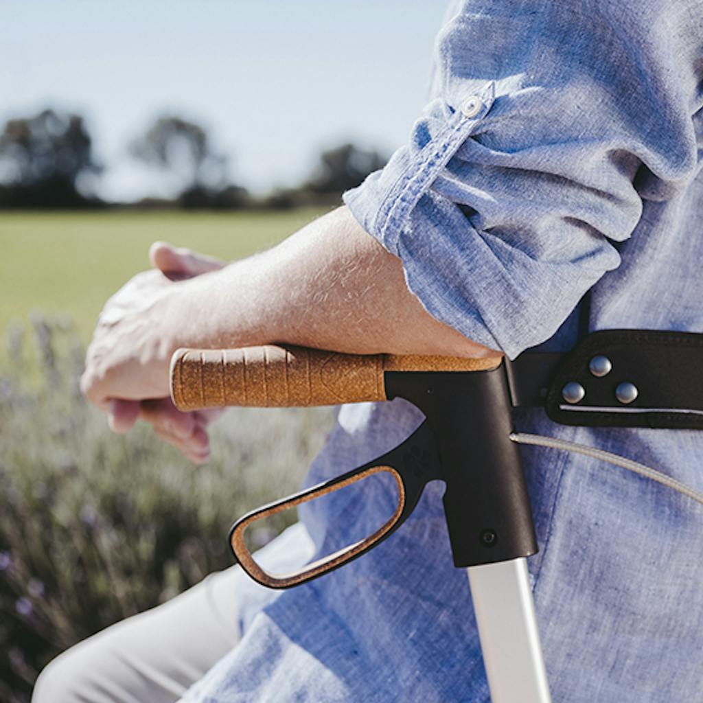 Mann lehnt auf den Korkgriffen des Saljol Carbon Rollators.