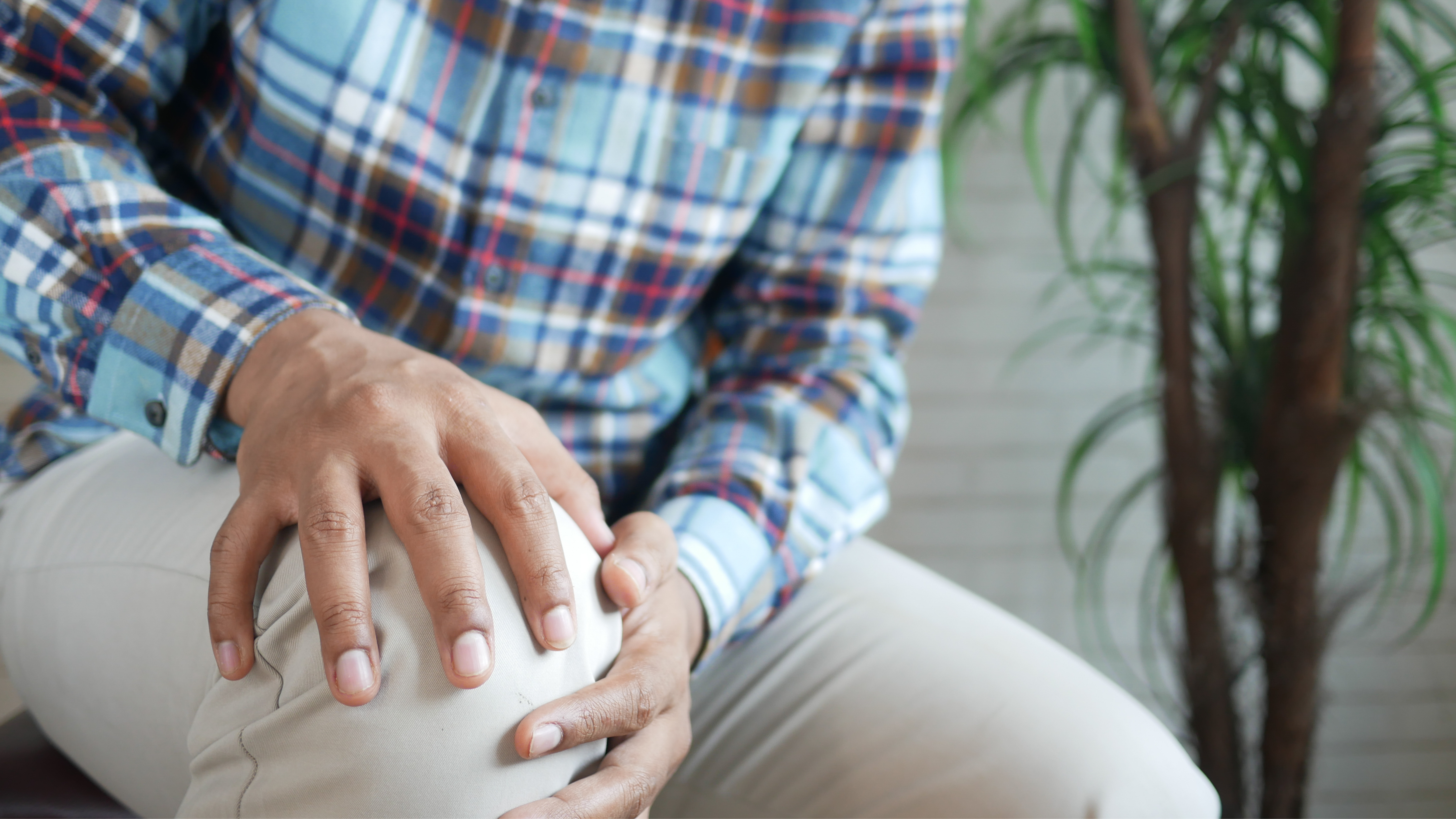 Mann greift sich an das schmerzende Knie