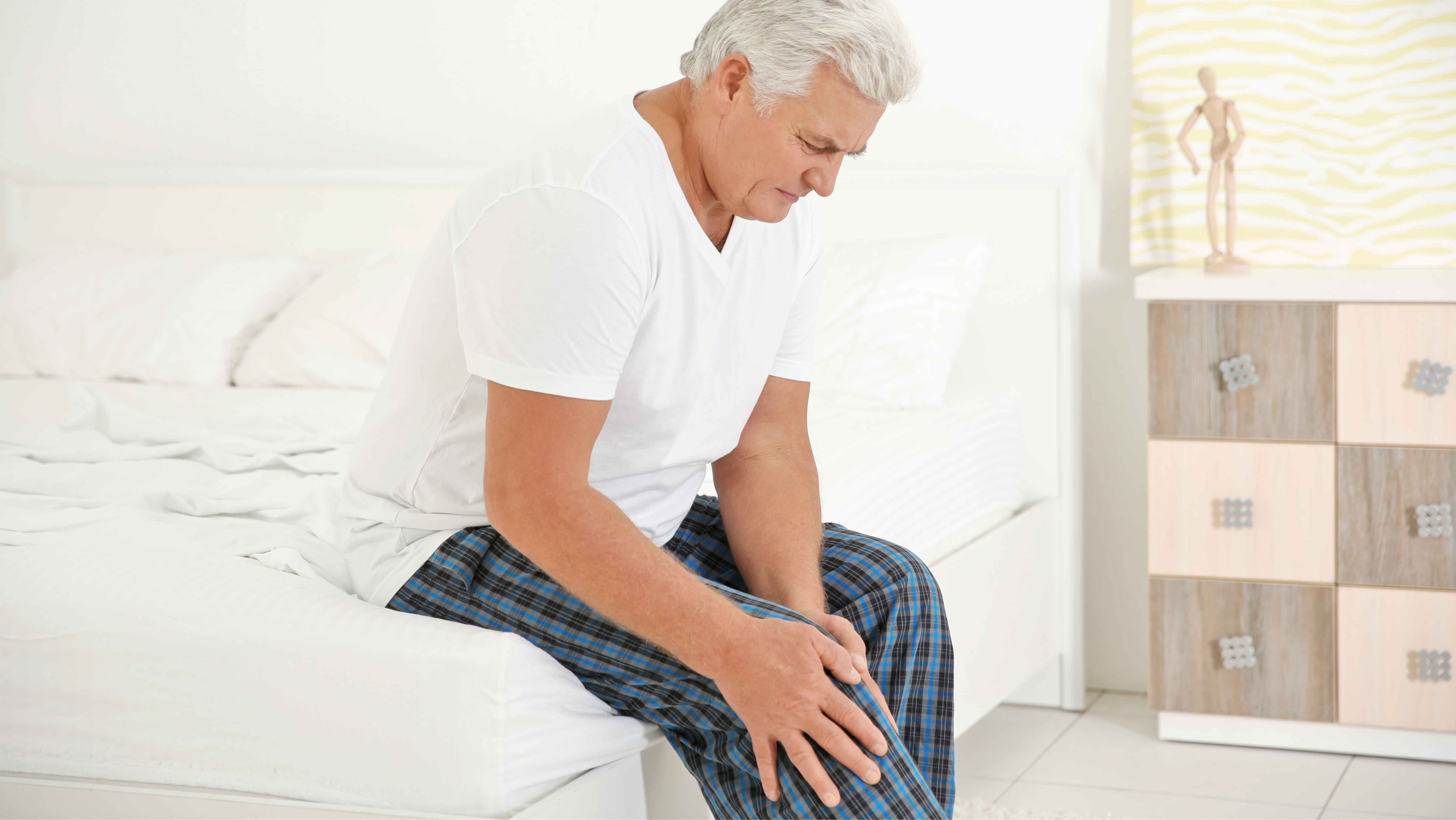 Mann greift sich an das schmerzende Knie