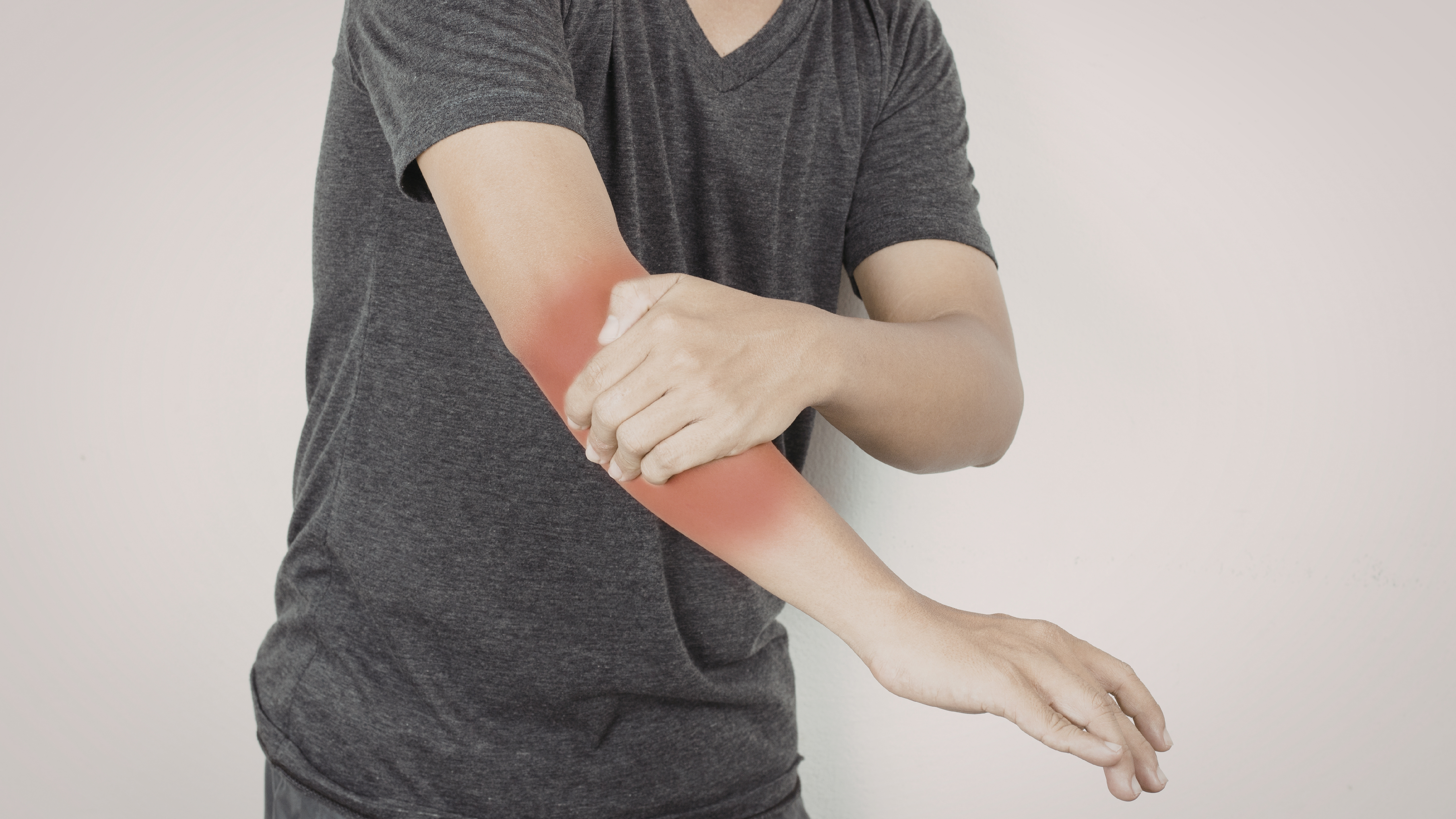Mann greift sich an den schmerzenden Ellenbogen
