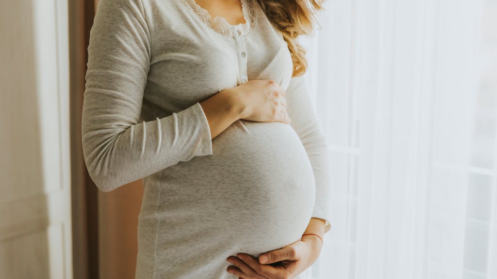 Fräu hält sich den schwangeren Bauch