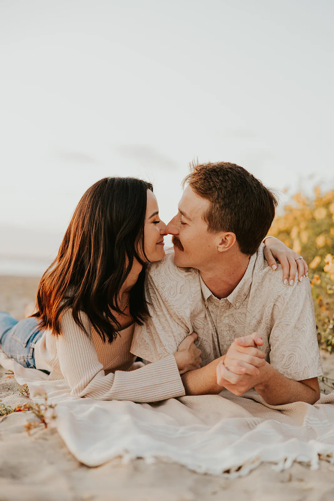 Couple on a blanket sharing noseys at San Clemente Beach