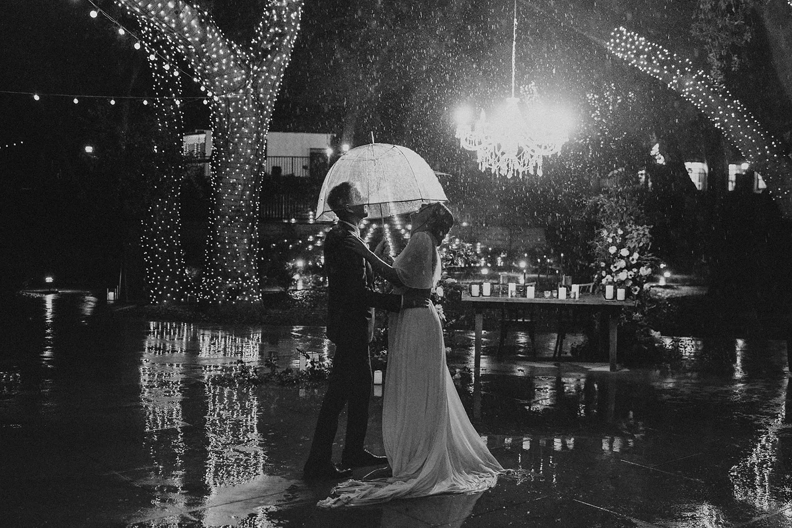 Bride and groom dancing in the pouring rain on their wedding day
