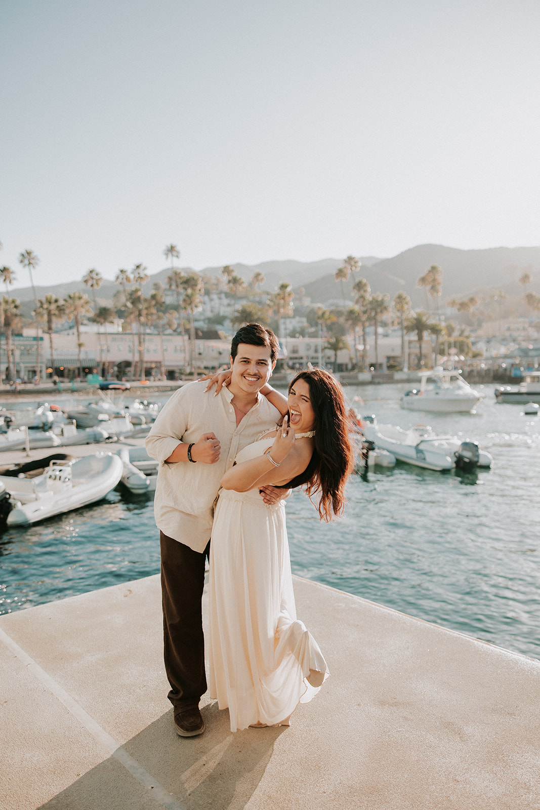 Couple who gets engaged on Catalina Island poses on a dock together 