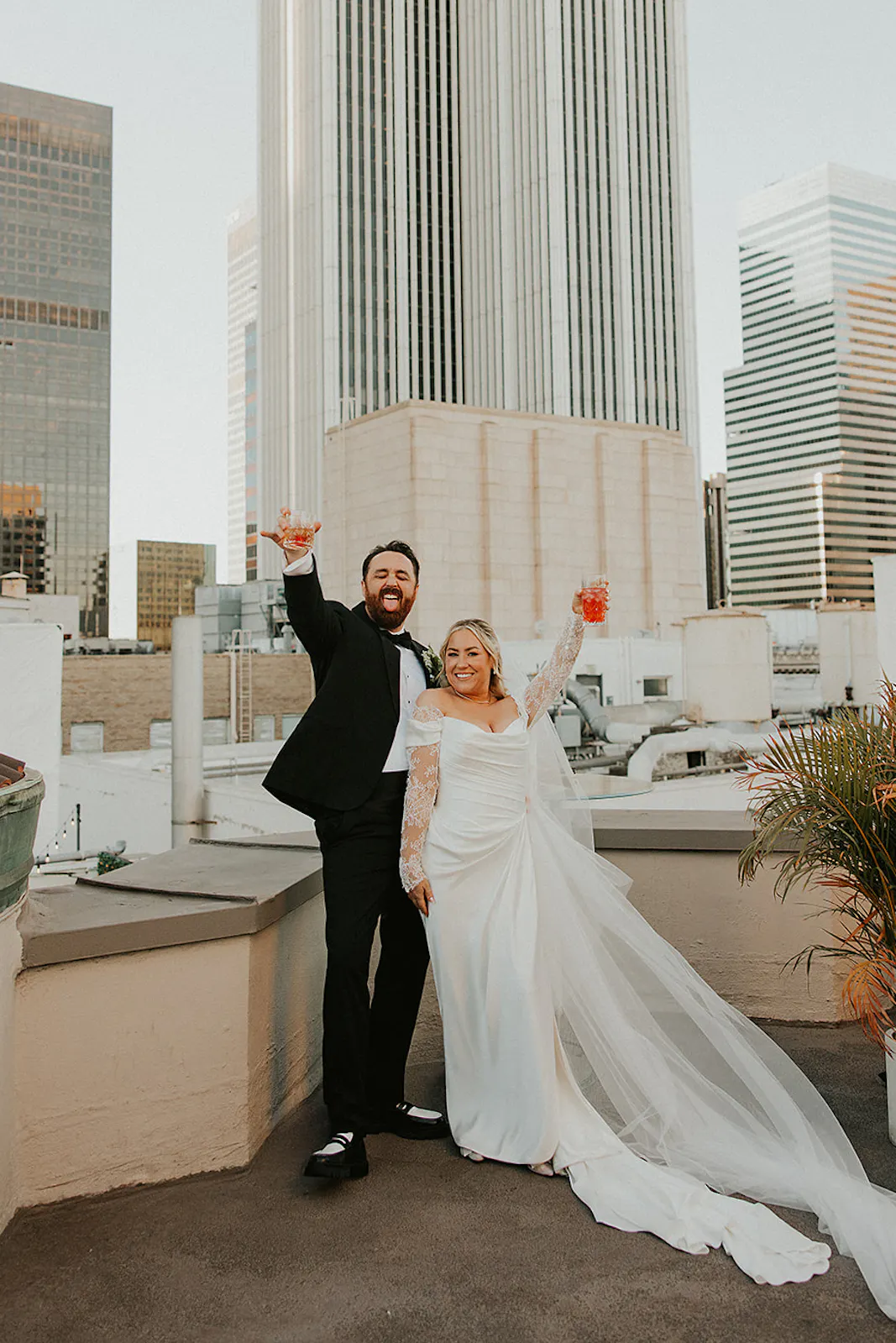 Couple sharing a cheers after getting married on a rooftop in DTLA at The Oviatt Penthouse
