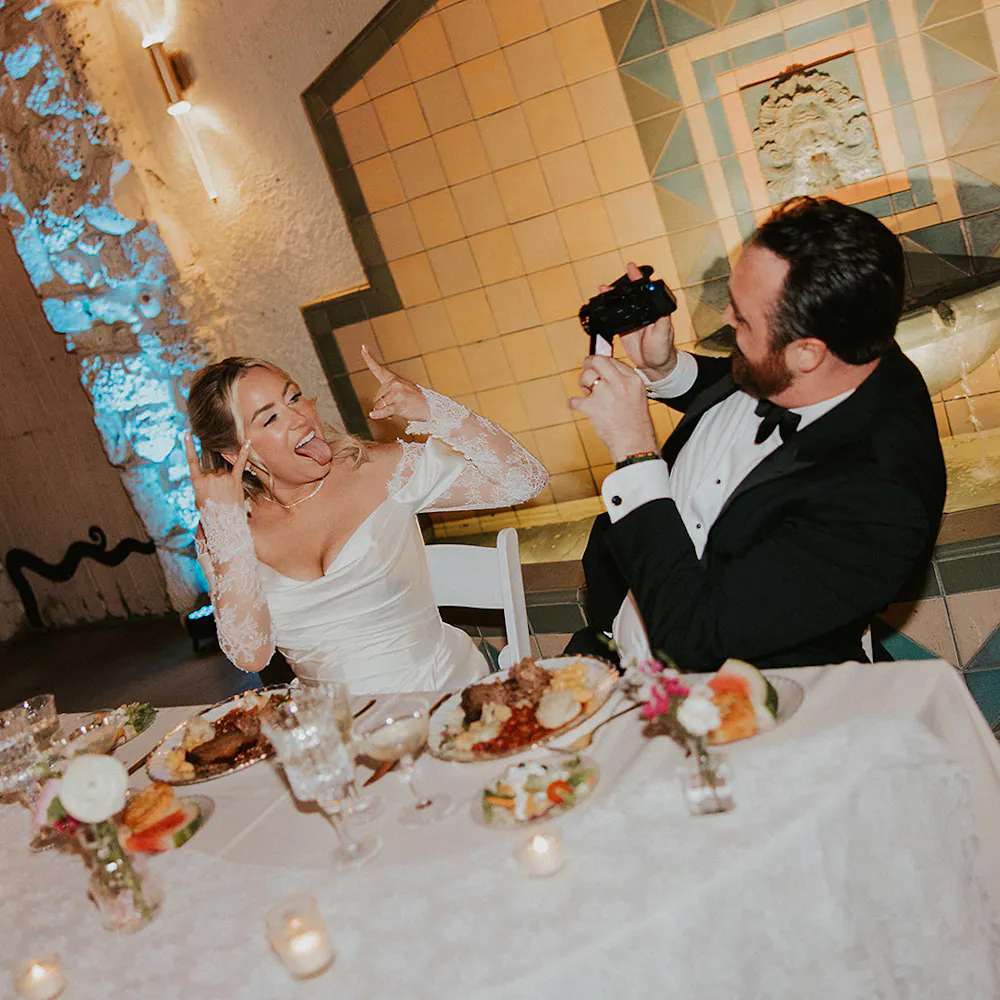 Couple photographing eachother at their wedding reception at the oviatt penthouse, los angeles