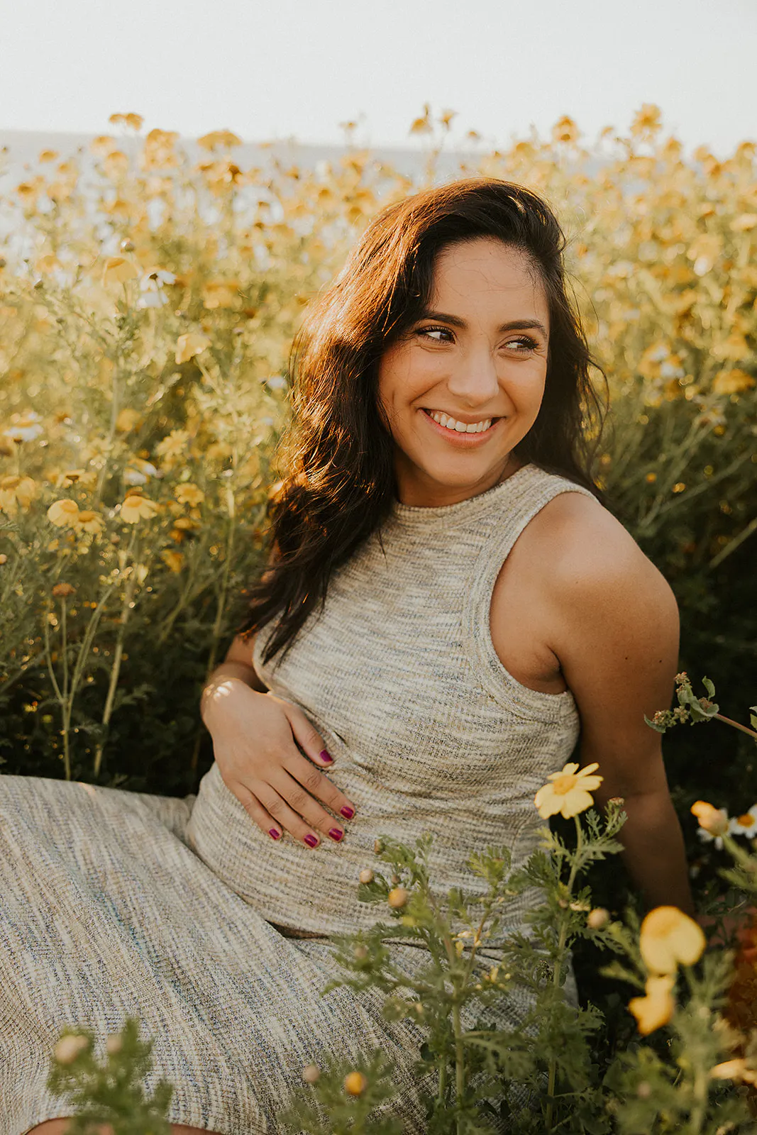 Pregnant mother poses in yellow wildflowers at maternity session