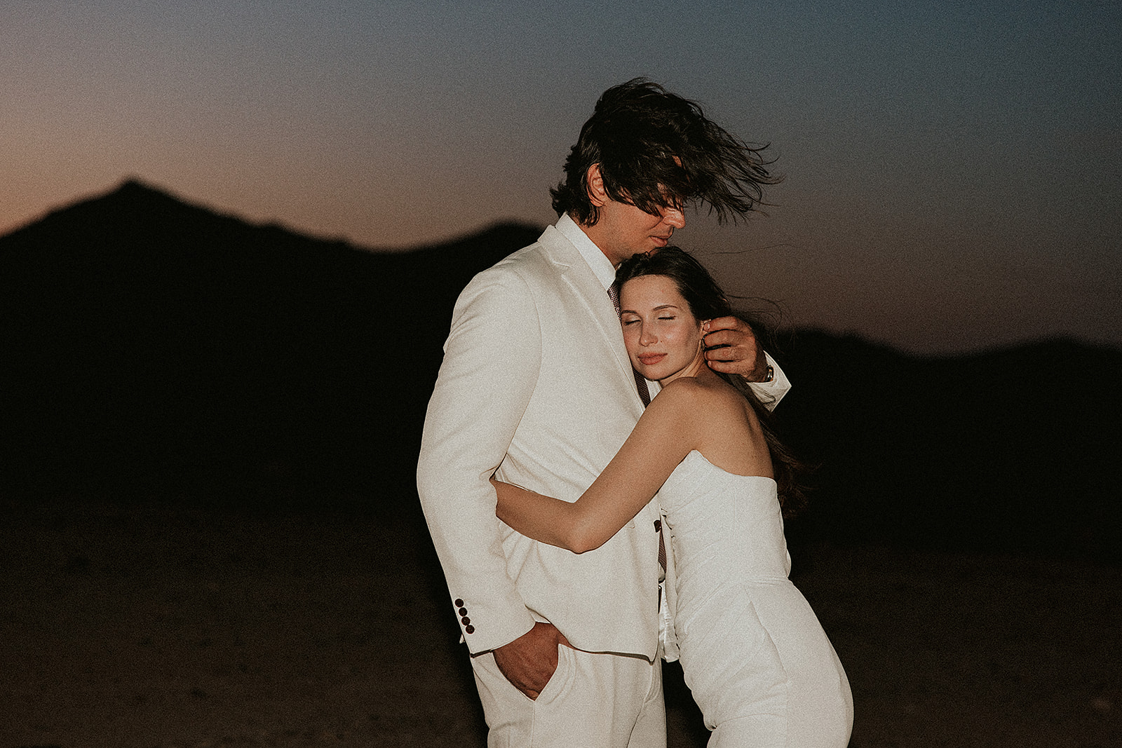 Joshua Tree Couple eloping in the desert embracing at sunset