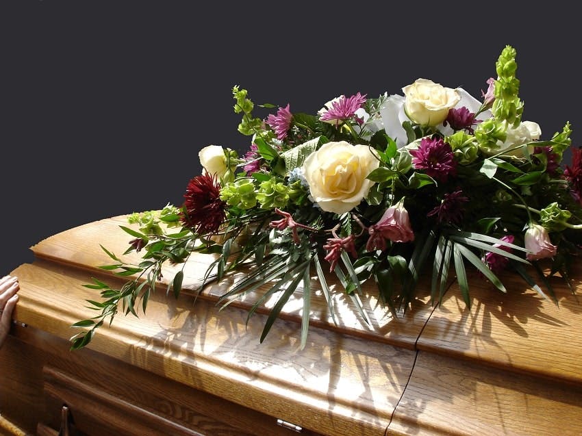 cercueil en bois avec fleurs de deuil