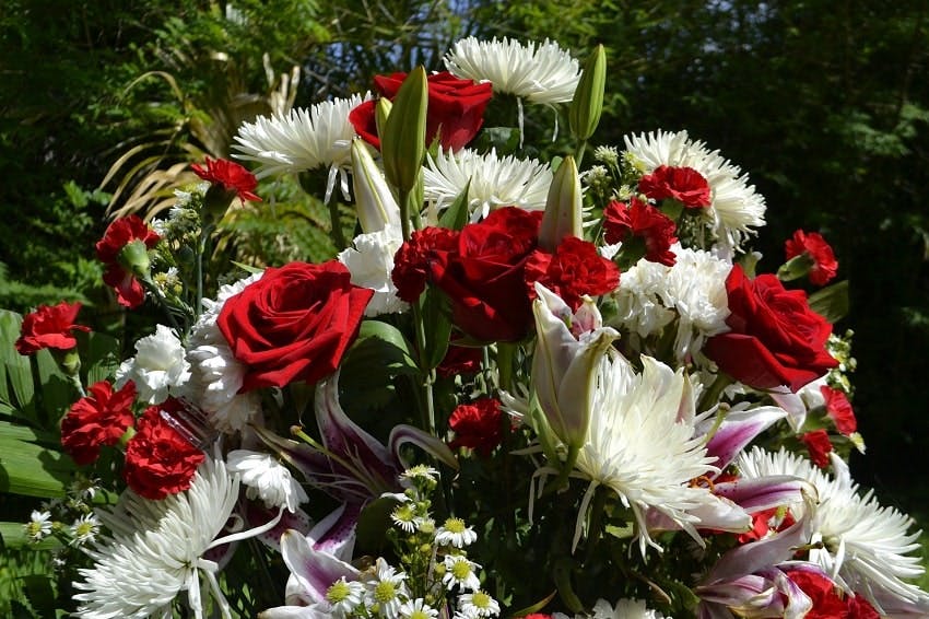 bouquet de deuil avec des roses rouges et des fleurs blanches 
