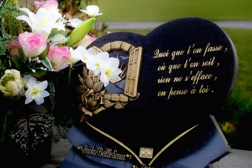plaque funéraire noire en forme de coeur avec des fleurs sur le côté