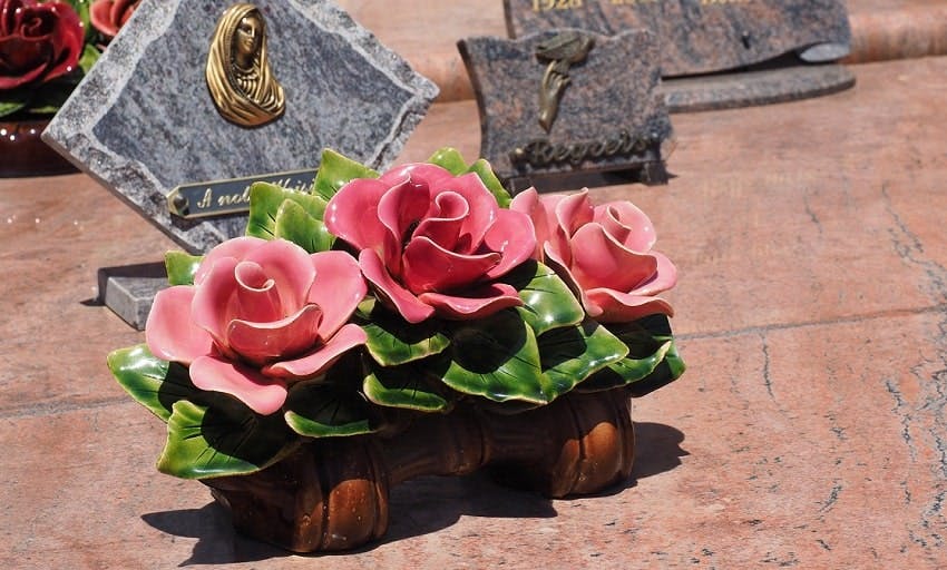 plaque funéraire avec trois roses rouges sur pierre tombale