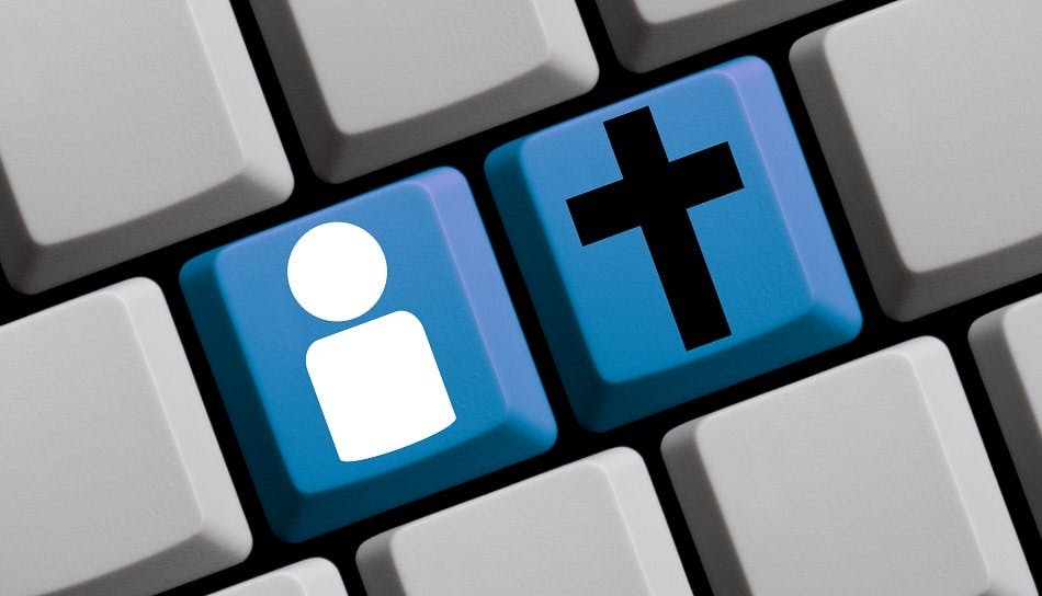 clavier d'ordinateur portant deux touches bleues représentant une personne et une croix