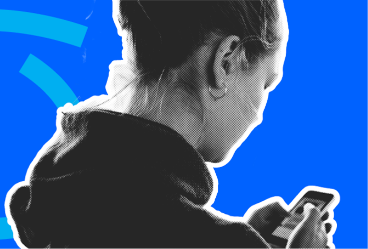 Ein Teenager-Mädchen hält ein Mobiltelefon in der Hand und schaut auf den Bildschirm.