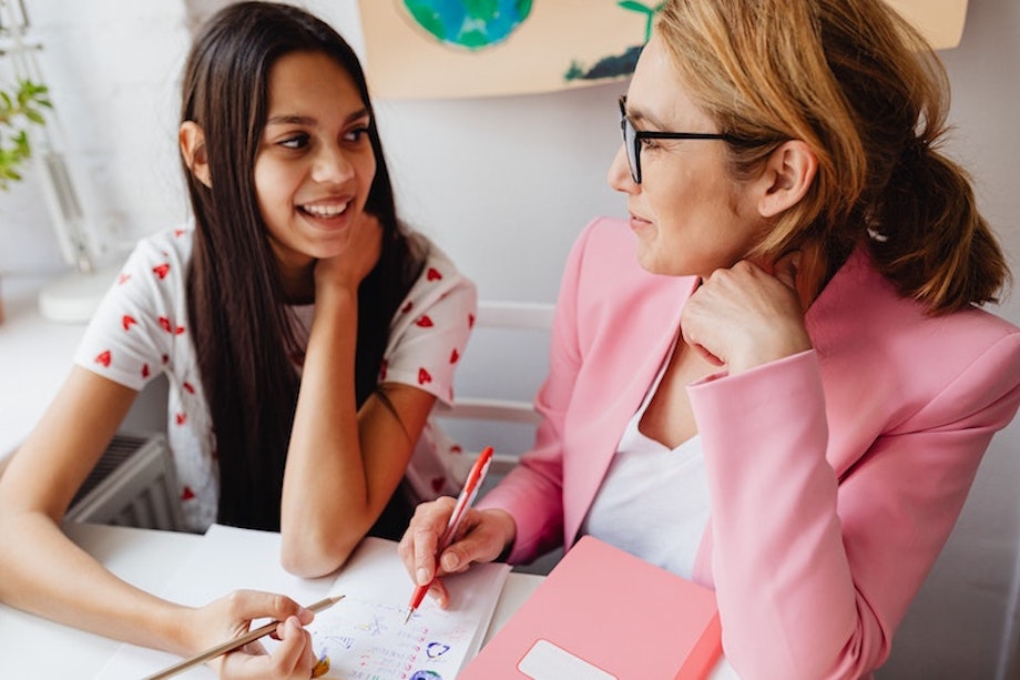 Eine Lehrerin setzt im Unterricht Methoden für Differenzierung an und unterstützt ihre Schülerin beim Lösen einer Aufgabe