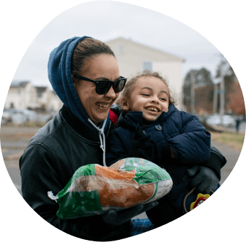 Woman and child smiling while holding food