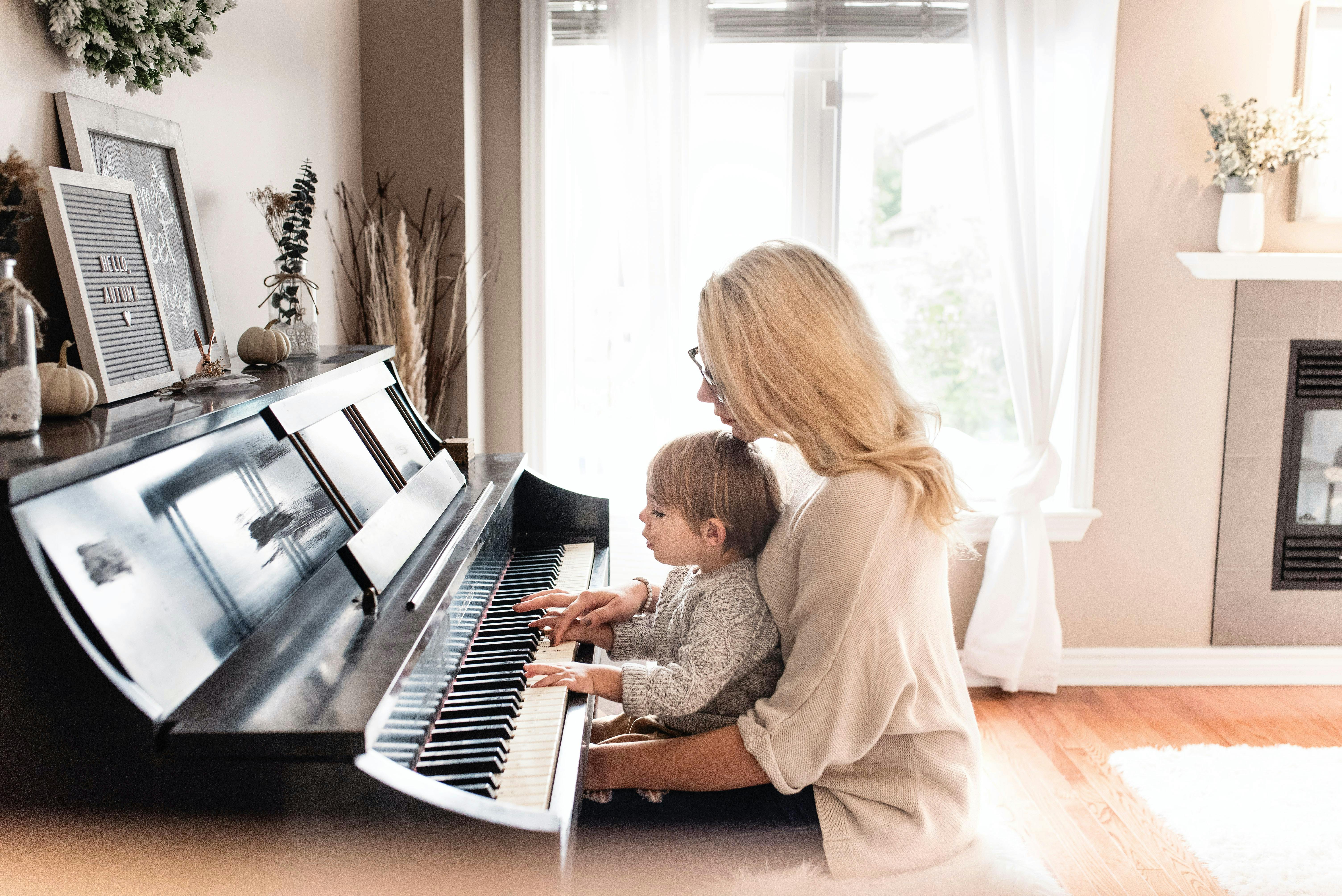 Mother teaching her child to play the piano