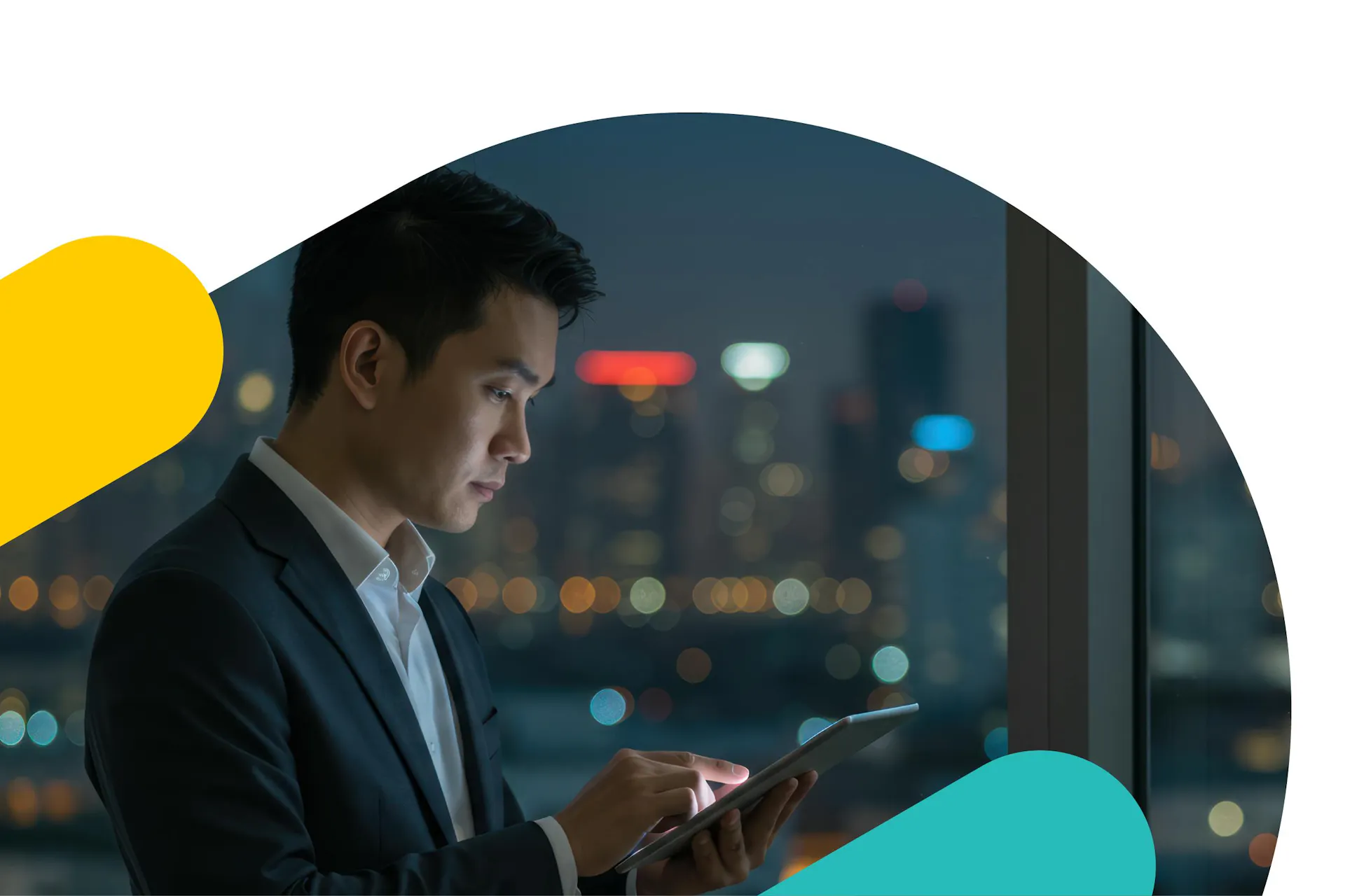 An asian man in a suit working on this tablet