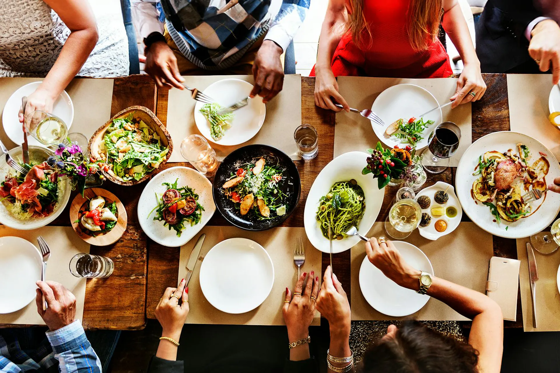 People seated at a dining table full of plates of food in this image for Meltwater's 2024 Consumer Insights: Food & Beverage report
