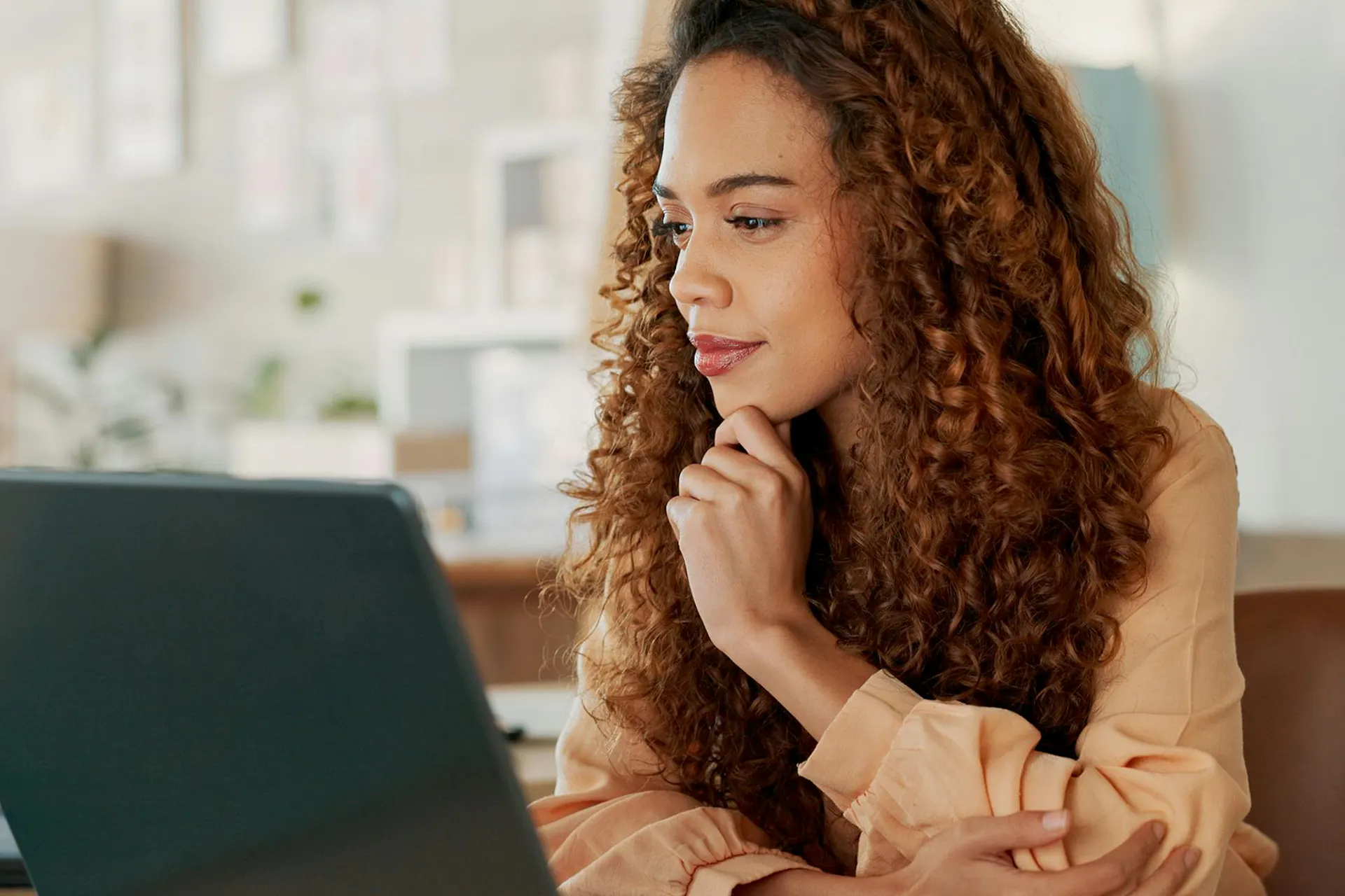 Woman looking with curiosity at a laptop on her desk